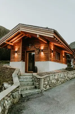 a log cabin with stairs leading to the door at Hôtel Restaurant La Ferme de Cupelin in Saint-Gervais-les-Bains