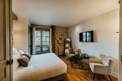 a bedroom with a bed and a table and a chair at Hôtel Restaurant La Ferme de Cupelin in Saint-Gervais-les-Bains