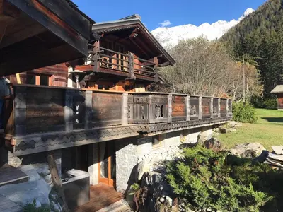 a bridge over a river in front of a house at CHALET ALBA in Chamonix-Mont-Blanc