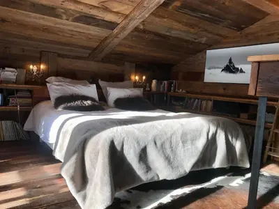 a bedroom with a large bed in a room with wooden ceilings at CHALET ALBA in Chamonix-Mont-Blanc