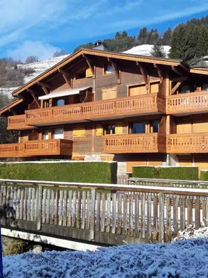 a balcony with a table and chairs on a house at Les Fermes Mégevannes in Megève