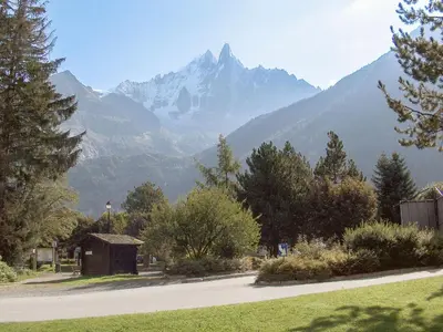a mountain in the distance with a road and trees at Apartment Champraz-15 by Interhome in Chamonix-Mont-Blanc
