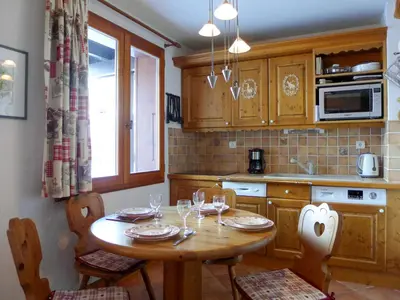 a kitchen with a wooden table with wine glasses at Apartment Le Plan des Reines by Interhome in Chamonix-Mont-Blanc