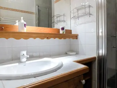 a white bathroom with a sink and a mirror at Apartment Le Plan des Reines by Interhome in Chamonix-Mont-Blanc