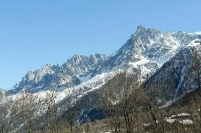 a snow covered mountain with trees in front of it at APARTMENT KANDAHAR - Alpes Travel - Central Chamonix - Sleeps 4 in Les Houches