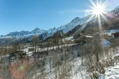 a snow covered mountain range with the sun in the sky at APARTMENT KANDAHAR - Alpes Travel - Central Chamonix - Sleeps 4 in Les Houches