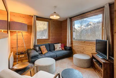 a living room with a couch and a television at APARTMENT KANDAHAR - Alpes Travel - Central Chamonix - Sleeps 4 in Les Houches