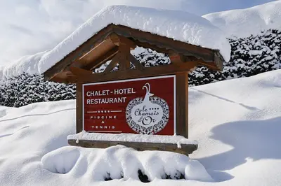 a sign in the snow in front of a mountain at Le Chamois d'Or in Cordon