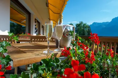 two glasses of champagne sitting on a wooden table with flowers at Le Chamois d'Or in Cordon