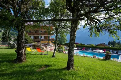 a resort with a swimming pool and trees in the grass at Le Chamois d'Or in Cordon