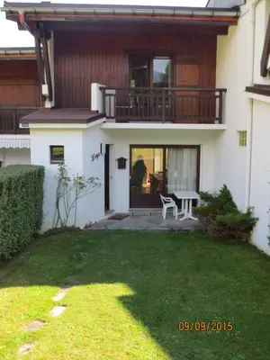 a house with a balcony and a table in the yard at L'Onyx - Domaine de Nant Cruy in Sallanches