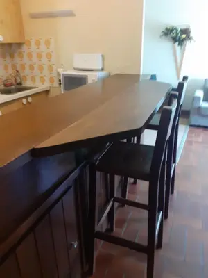 a kitchen with a wooden table and some chairs at L'Onyx - Domaine de Nant Cruy in Sallanches