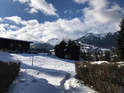 a snow covered yard with mountains in the background at L'Onyx - Domaine de Nant Cruy in Sallanches