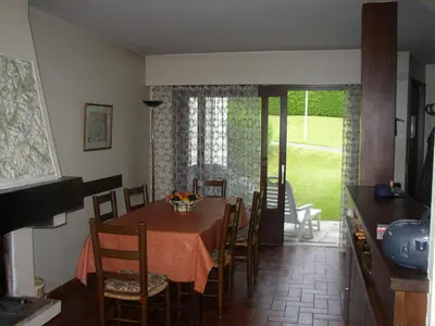a dining room with a table and chairs and a kitchen at L'Onyx - Domaine de Nant Cruy in Sallanches