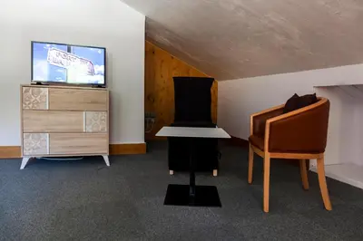 a room with a tv and a table and a chair at Appartement Le Galetas des Planards in Chamonix-Mont-Blanc