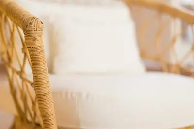 a wicker chair sitting next to a white couch at Appartement Le Galetas des Planards in Chamonix-Mont-Blanc