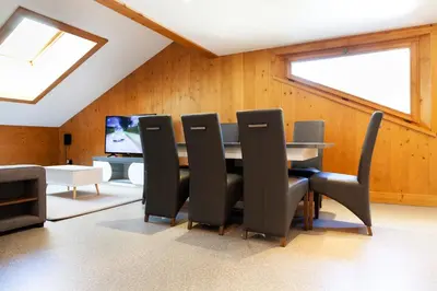 a dining room with a table and chairs and a television at Appartement Le Galetas des Planards in Chamonix-Mont-Blanc