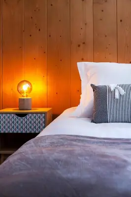 a bedroom with a bed with a lamp on a table at Appartement Le Galetas des Planards in Chamonix-Mont-Blanc