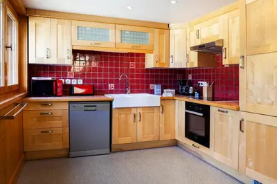 a kitchen with wooden cabinets and a sink at Appartement Le Galetas des Planards in Chamonix-Mont-Blanc