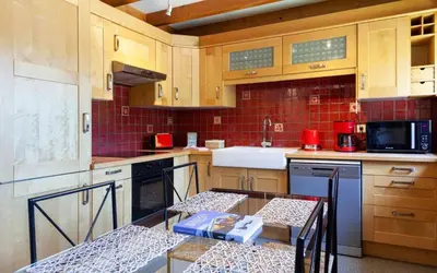 a kitchen with wooden cabinets and a table in it at Appartement Le Caboen Les Planards in Chamonix-Mont-Blanc