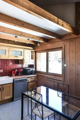 a kitchen with two chairs and a table in it at Appartement Le Caboen Les Planards in Chamonix-Mont-Blanc
