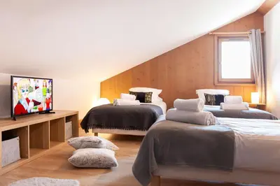 a bedroom with two beds and a tv in it at Appartement Le Mazot Vue Mont Blanc in Chamonix-Mont-Blanc