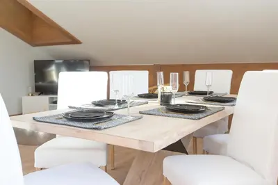 a dining room table with plates and glasses on it at Appartement Le Mazot Vue Mont Blanc in Chamonix-Mont-Blanc