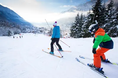 two people are skiing down a snow covered slope at Appartement Le Mazot Vue Mont Blanc in Chamonix-Mont-Blanc