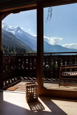 a room with a balcony with a view of the mountains at Appartement Le Mazot Vue Mont Blanc in Chamonix-Mont-Blanc