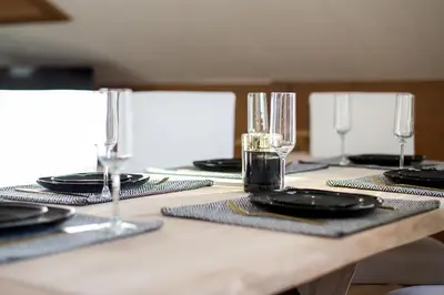 a table with plates and glasses on top at Appartement Le Mazot Vue Mont Blanc in Chamonix-Mont-Blanc