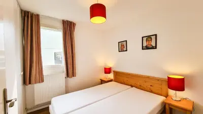 a bedroom with a white bed and two lamps at Residence les Pleiades in Flaine