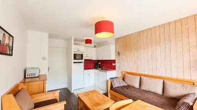 a small kitchen with white cabinets and red tiles at Residence les Pleiades in Flaine