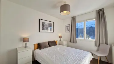 a living room with a table and a large window at Residence les Pleiades in Flaine