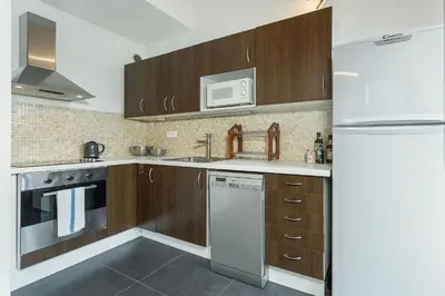 a kitchen with wooden cabinets and a white refrigerator at Apartment Balme 5 - Chamonix Mont Blanc in Chamonix-Mont-Blanc