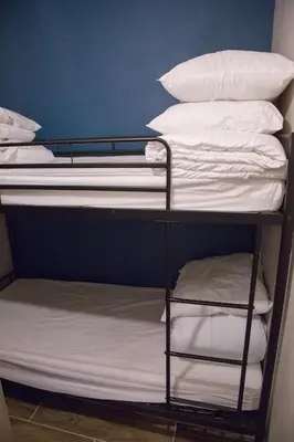 a bunk bed with white sheets and pillows on it at Castel des roches Leal Julien in Saint-Gervais-les-Bains