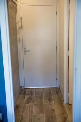 a white door in a hallway with a tile floor at Castel des roches Leal Julien in Saint-Gervais-les-Bains