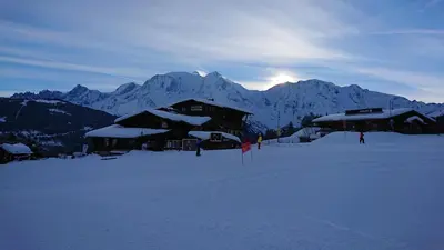 a ski lodge with snow covered mountains in the background at Castel des roches Leal Julien in Saint-Gervais-les-Bains