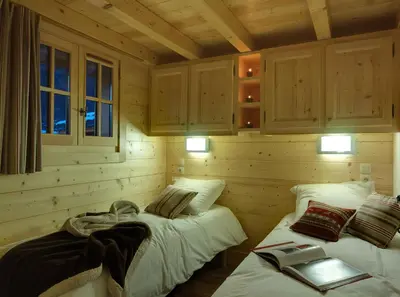 a room with two beds in a log cabin at Chalets Ile des Barrats in Chamonix-Mont-Blanc