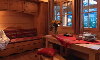 a room with a bench and a table with plates at Chalets Ile des Barrats in Chamonix-Mont-Blanc