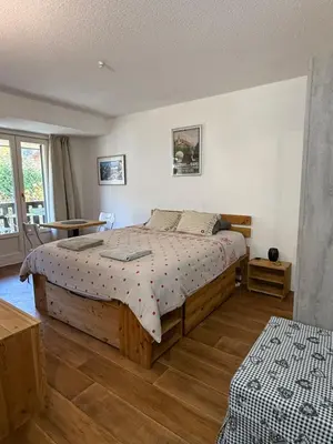 a bedroom with a wooden bed and a window at La Comtesse in Saint-Gervais-les-Bains
