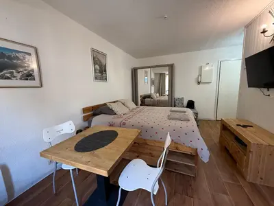 a bedroom with a bed and a wooden table and chairs at La Comtesse in Saint-Gervais-les-Bains