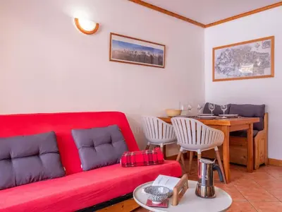 a living room with a red couch and a table at Petite Jardin: Residence Via des Traz B in Chamonix-Mont-Blanc