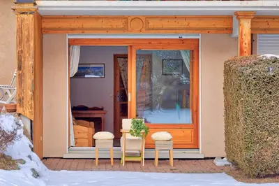 a table and two chairs in front of a door at Petite Jardin: Residence Via des Traz B in Chamonix-Mont-Blanc