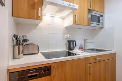 a small kitchen with a sink and a stove at Petite Jardin: Residence Via des Traz B in Chamonix-Mont-Blanc