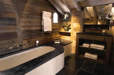 a living room with a couch and a table with a bowl of fruit at Zannier Le Chalet in Megève