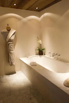 a white bath tub in a bathroom with a plant at Zannier Le Chalet in Megève