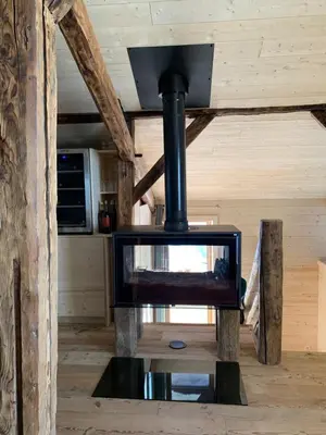 a woodburning stove in a room with a kitchen at Chalet De Praz Dru in Les Houches