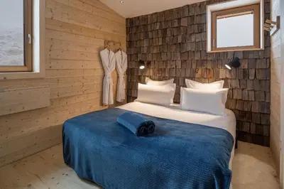 a bedroom with a bed with a blue blanket at Chalet De Praz Dru in Les Houches