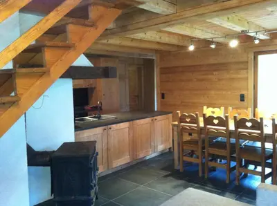 a kitchen with wooden cabinets and a table and chairs at Chalet Narcisse in Sixt