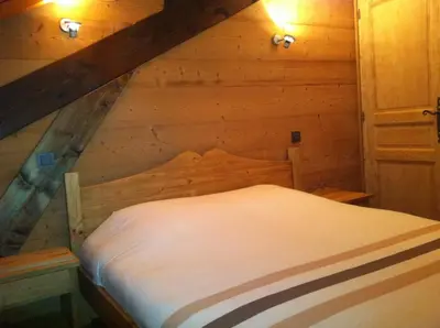 a bed in a wooden room in a attic at Chalet Narcisse in Sixt